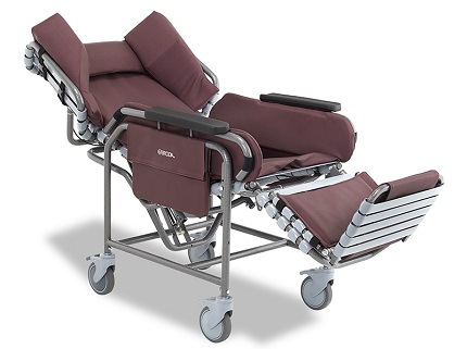 Broda Centric Positioning Wheelchair, reclined The Broda Centric positioning wheelchair with burgundy padding, shown in a reclined position with the footrest extended.