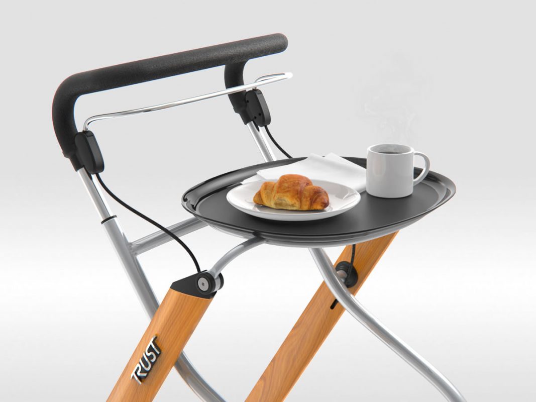 The Let's Go Indoor Rollator is shown in the Beech colour, with the removable tray. Someone is feeling peckish because the tray has a croissant and a mug of coffee on it.