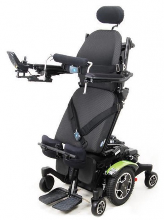 The ROVI A3 power wheelchair with green trim in the standing position with seatbelt and knee blocks.