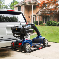 An Out-Sider scooter lift is lifted on the back of a SUV