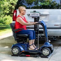 A woman sits on her scooter after having driven onto her Out-Sider scooter lift thumbnail