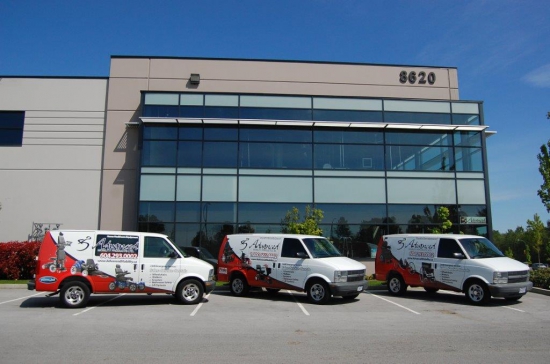 National Seating & Mobility Burnaby exterior The mirrored exterior of the Burnaby showroom with logoed vans parked in front.